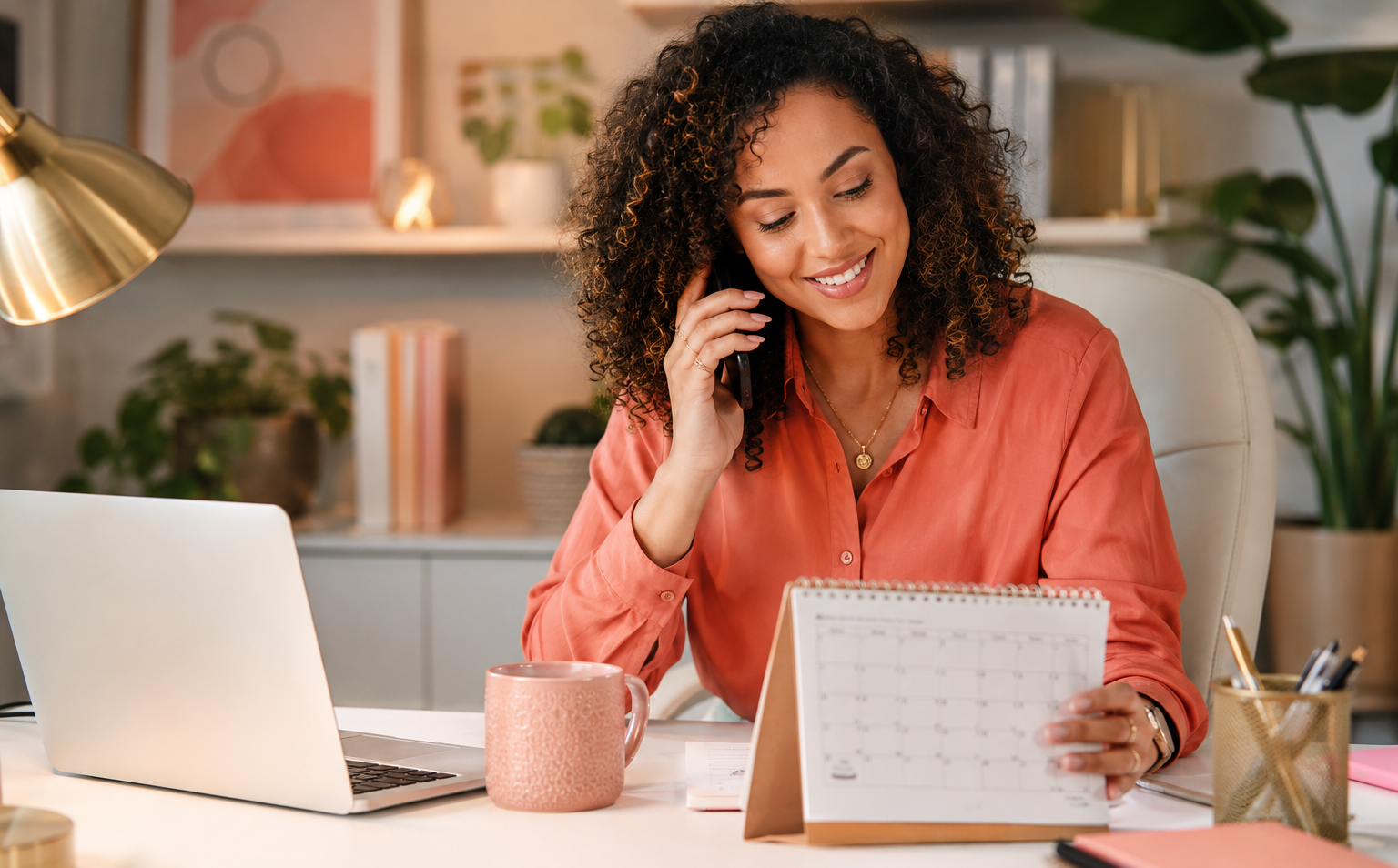 Mãe empreendedora ao telefone olhando calendário no escritório em casa